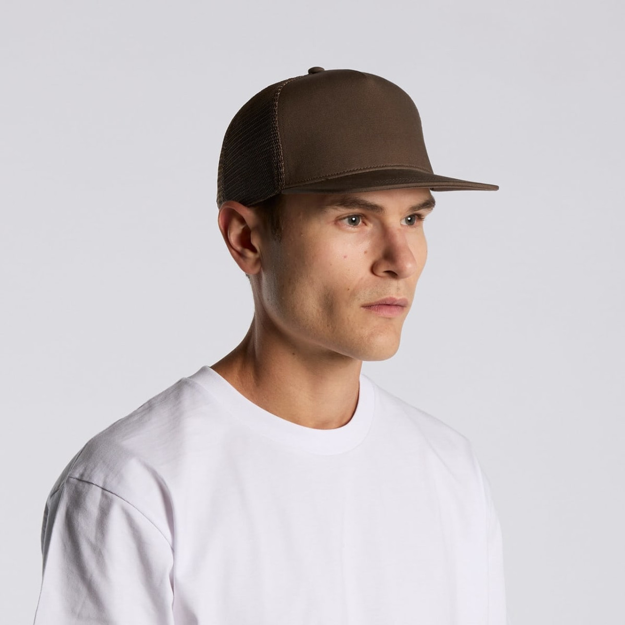 A brown trucker cap with a mesh back, worn by a person in a white t-shirt, facing sideways.