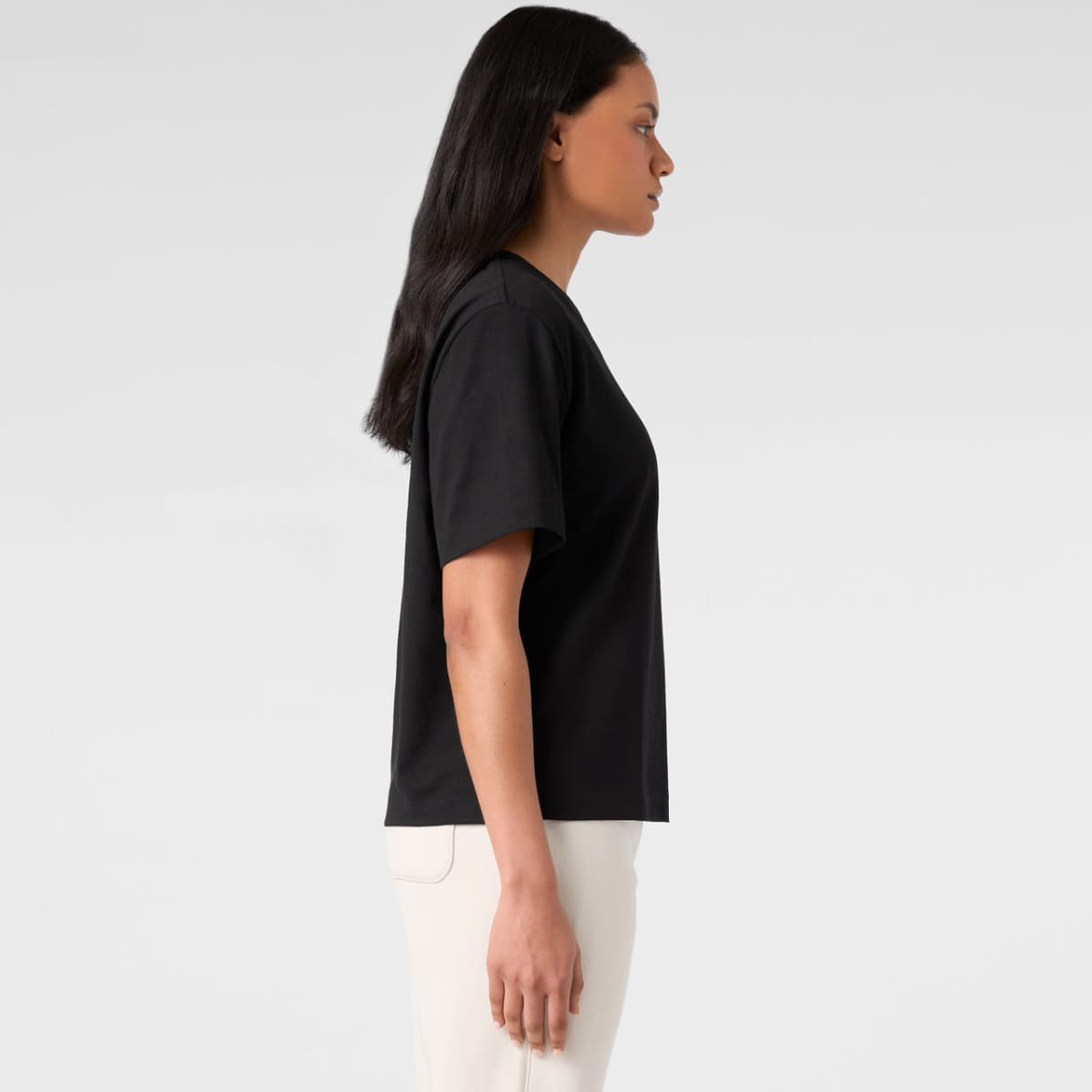 A black short-sleeve tee displayed on a model from the side, featuring a relaxed fit.