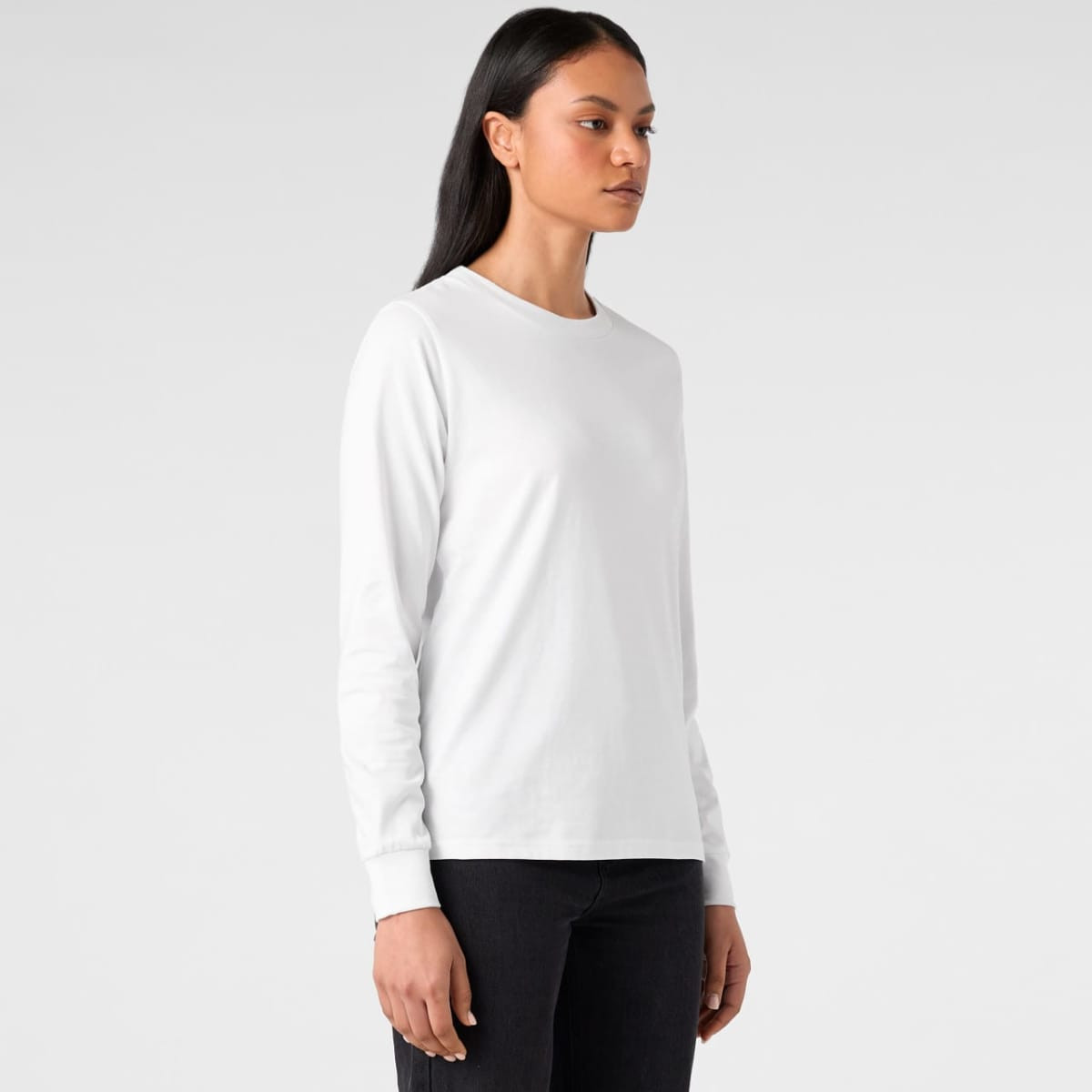 A long-sleeve white T-shirt made of soft fabric, featuring a fitted design and a logo on the sleeve.