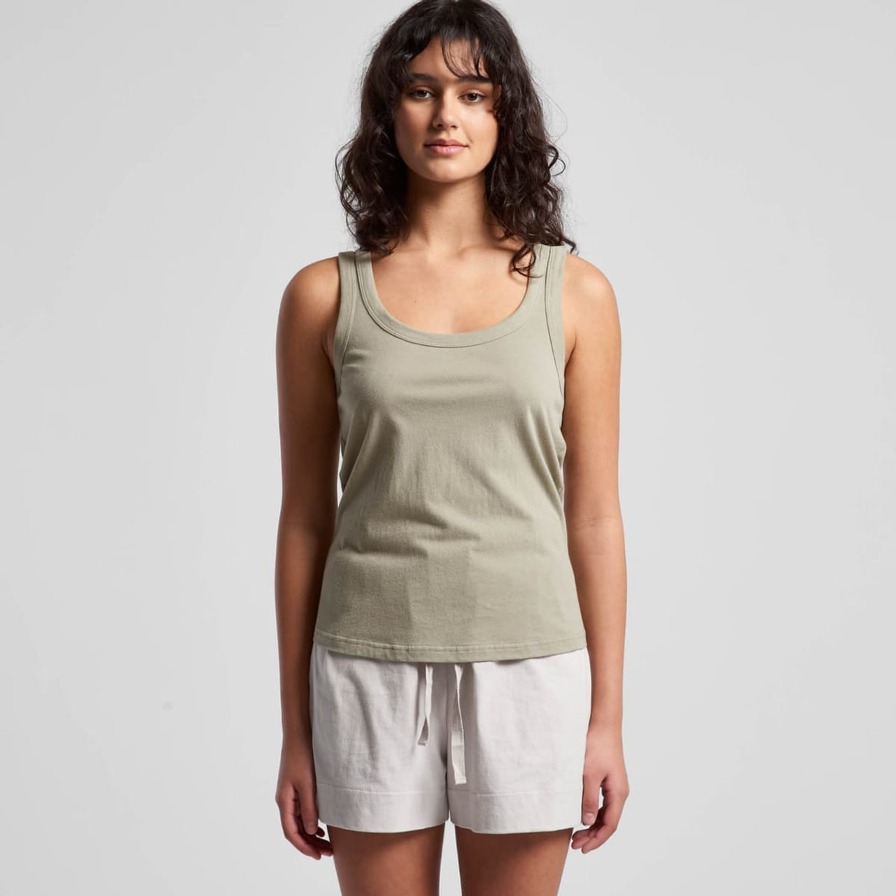 A soft green singlet paired with white shorts, featuring a simple design and a logo on the fabric.