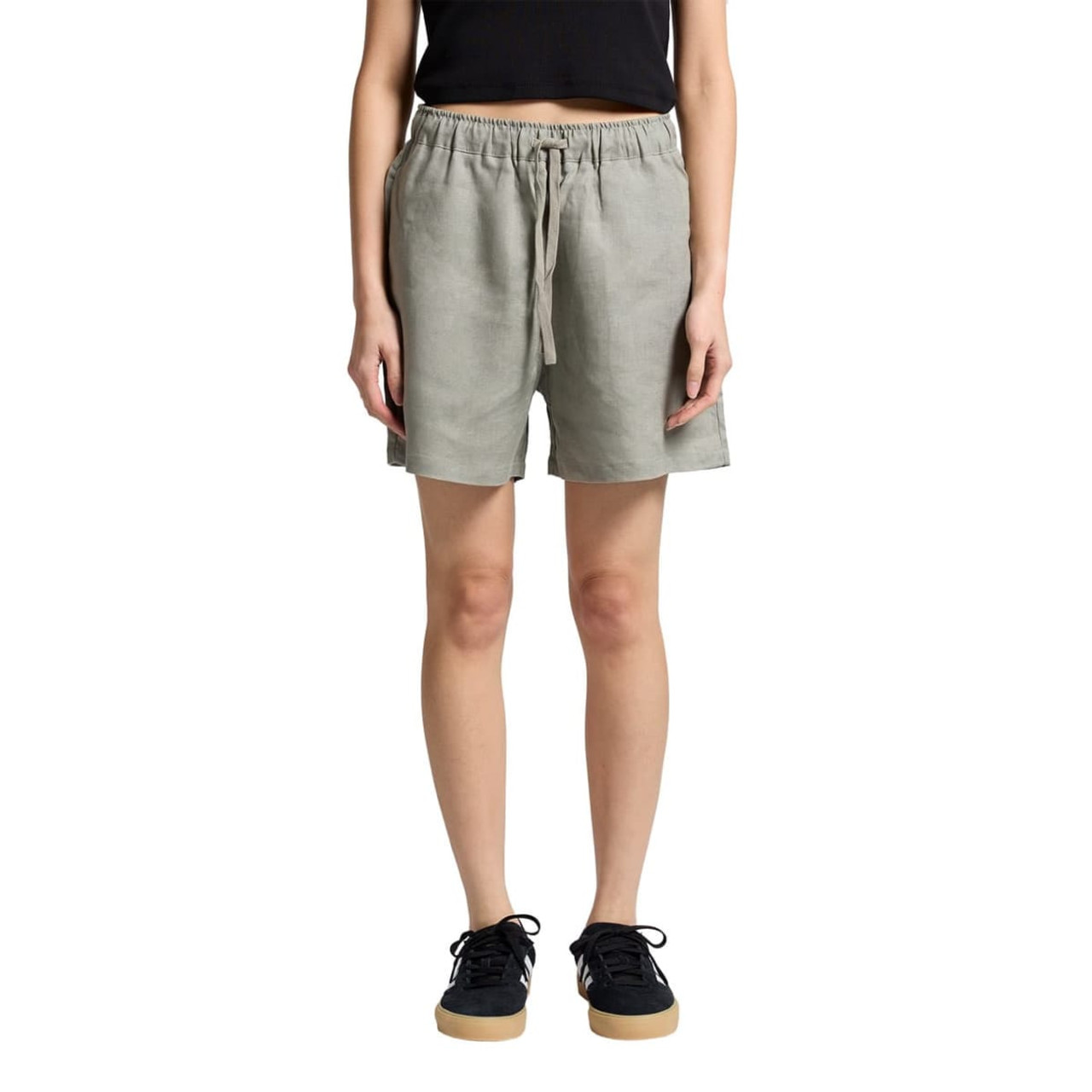 Linen shorts in light green with an elastic waistband, paired with casual black footwear.