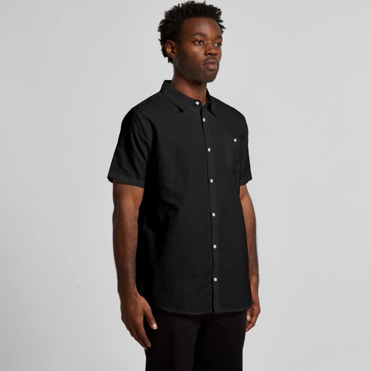 A short-sleeved black Oxford shirt with button-up design, featuring a chest pocket and a logo.