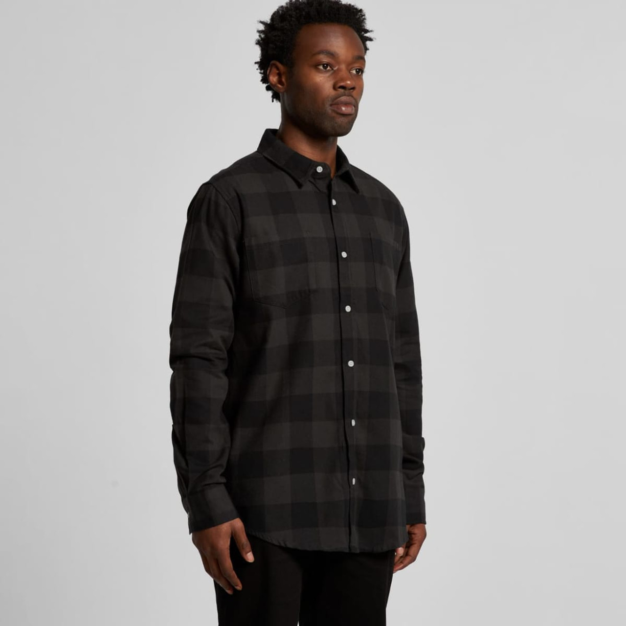 A button-up shirt in black and grey check pattern, featuring long sleeves and a collar, with a logo present.