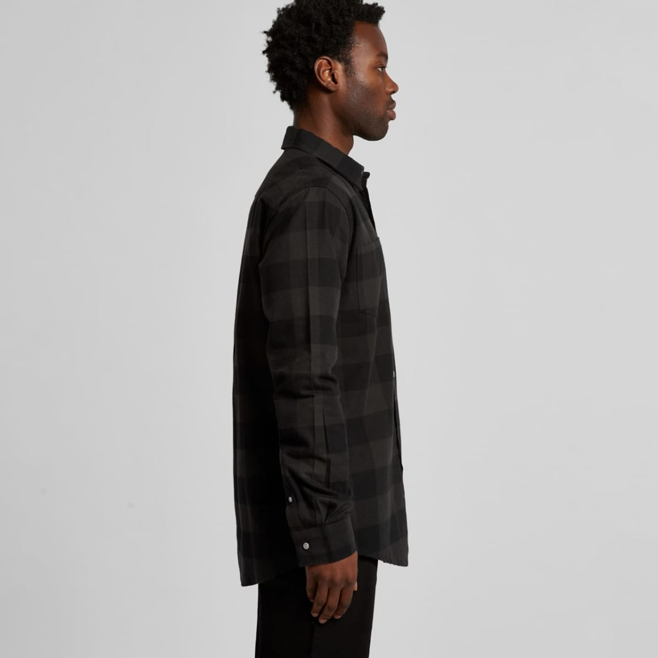 A side view of a black check shirt featuring a collar and button-up front, displayed on a model.