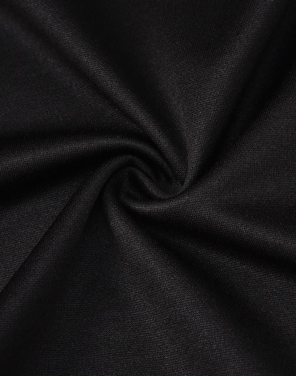 A close-up of black fabric showing a smooth texture, ideal for a polo shirt. The fabric has a slight sheen and flexibility.