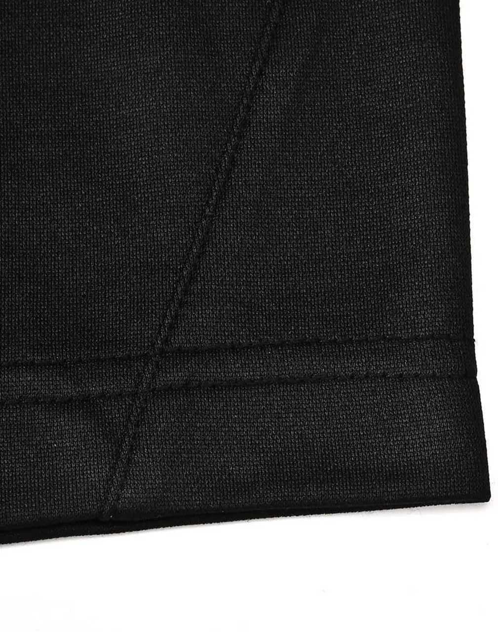 A close-up of a black polo shirt with a contrast sleeve hem and stitching detail. Features a logo on the side.