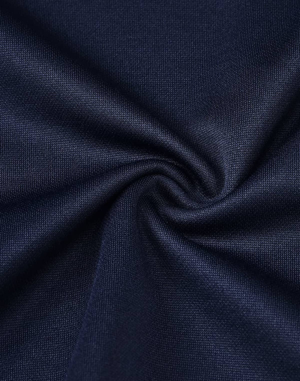 A close-up view of dark navy fabric with a smooth texture, featuring a twist. The material appears soft and breathable.