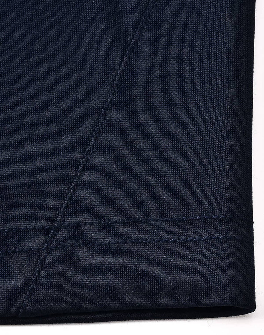 A close-up of the navy fabric of a polo shirt showcasing textured stitching details.