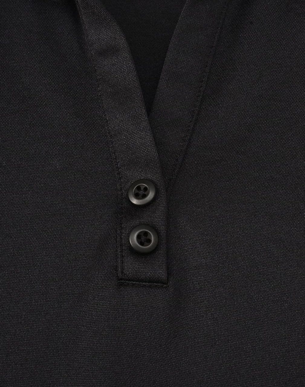 A black polo shirt featuring a textured fabric and two buttons at the neckline. It has a logo on it.