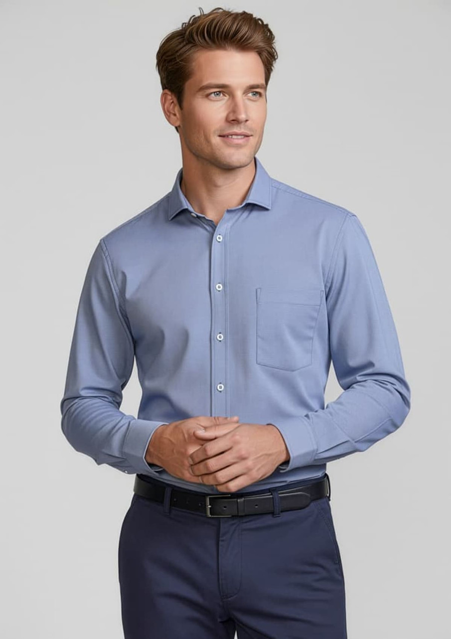 A blue long sleeve button-up shirt with a chest pocket, worn by a smiling man. The shirt features a logo.