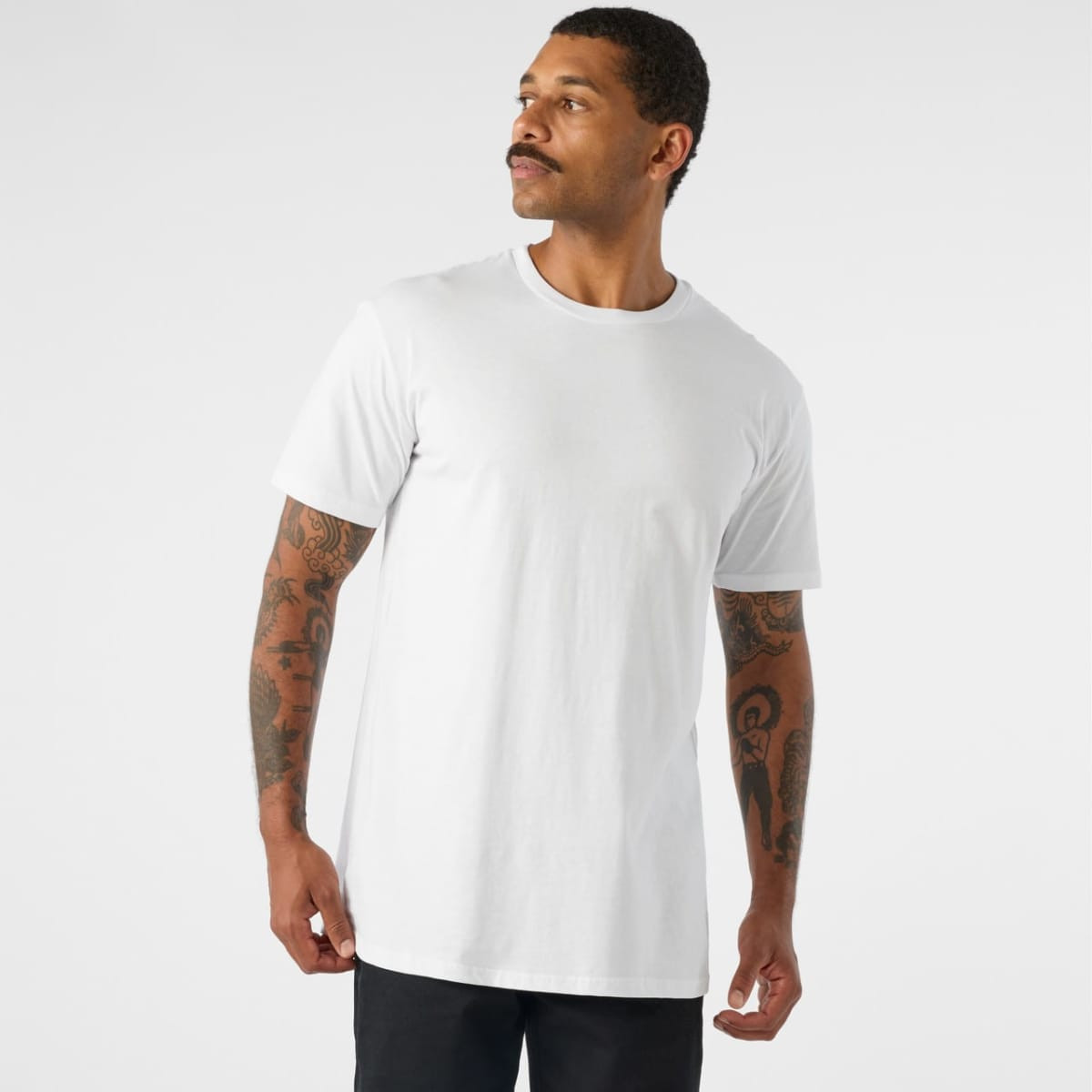 A man wearing a plain white basic tee, showcasing a classic fit and short sleeves.