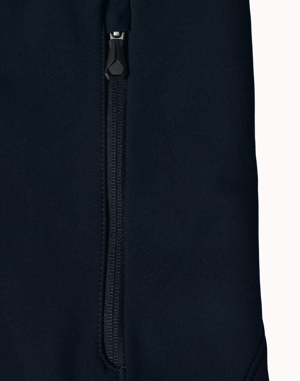 A dark navy softshell jacket featuring a zippered pocket and a sleek design. The jacket also has a logo.