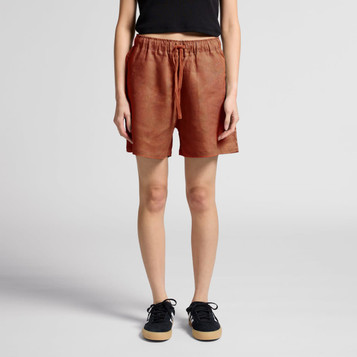 A pair of rust-coloured linen shorts with an elastic waistband and drawstring, featuring two side pockets.