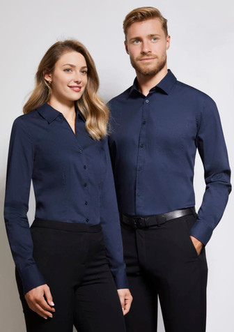 A pair of models wearing a navy blue women's long sleeve button-up shirt and a matching men's shirt, both with collars.