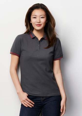 A women’s short sleeve polo in charcoal grey with red accents, featuring a collar and a logo.
