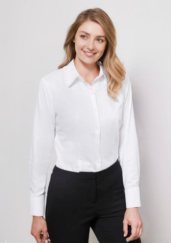 A white women's long sleeve button-up shirt displayed on a model, paired with black trousers.