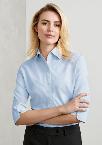 A light blue women's button-up shirt with 3/4 sleeves and a collar, featuring a logo.