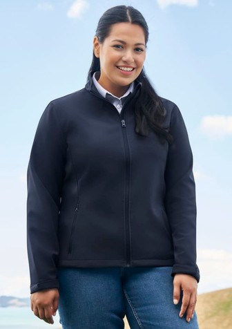 A black soft shell jacket with a zip front, worn by a woman outdoors against a scenic backdrop.