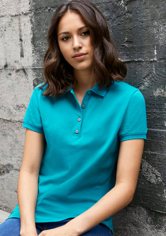A turquoise women's short sleeve polo shirt featuring a collar and button detail, set against a textured grey background.