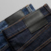 Two pairs of jeans in blue and dark denim, featuring leather patches and contrasting stitching.
