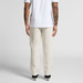 Linen pants in a light beige colour, featuring a relaxed fit and worn with a plain white t-shirt and shoes.