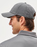 A grey 4-way stretch cap featuring laser cut ventilation, designed for comfort, with an adjustable strap and branding.