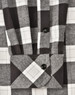 A black and white checkered flannel button-up shirt with a folded cuff, featuring a logo.
