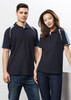 A navy blue short sleeve polo shirt featuring light blue accents, displayed on a male and female model. The shirt has a logo.