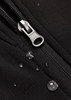 A close-up of a black soft shell jacket featuring a zipper and droplets of water on the fabric.