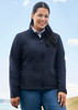 A black soft shell jacket with a zip front, worn by a woman outdoors against a scenic backdrop.