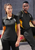 A black and yellow Women's Renegade Short Sleeve Polo, featuring a logo, displayed on a model against an urban backdrop.