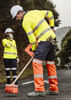 Hi-vis yellow and orange work pants with reflective tape, worn by a worker sweeping the road. A colleague is in the background.