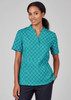 A teal tunic featuring a circular daisy print, designed with short sleeves and a relaxed fit. Includes a logo.