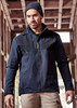 A man wears a navy blue unisex waterproof jacket with a hood. The jacket has a logo and is styled for casual wear.