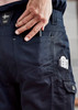 Navy cargo pants featuring multiple pockets, including a phone holder and a pocket for tools. Includes a branding logo.