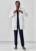 A longline lab coat in white worn over navy scrubs, featuring a logo on the coat.