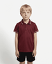 A maroon polo shirt for kids with contrasting trim, featuring a logo. Styled with a plain black bottom.