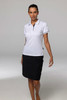 A woman is wearing a white polo shirt paired with a black skirt, standing on a neutral background. The polo has a logo.