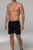 Black training men's shorts on a model, with an elastic waistband and a simple design. Features a logo.