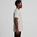 A side view of a beige Staple Tee T-shirt on a model, featuring short sleeves and a simple design.