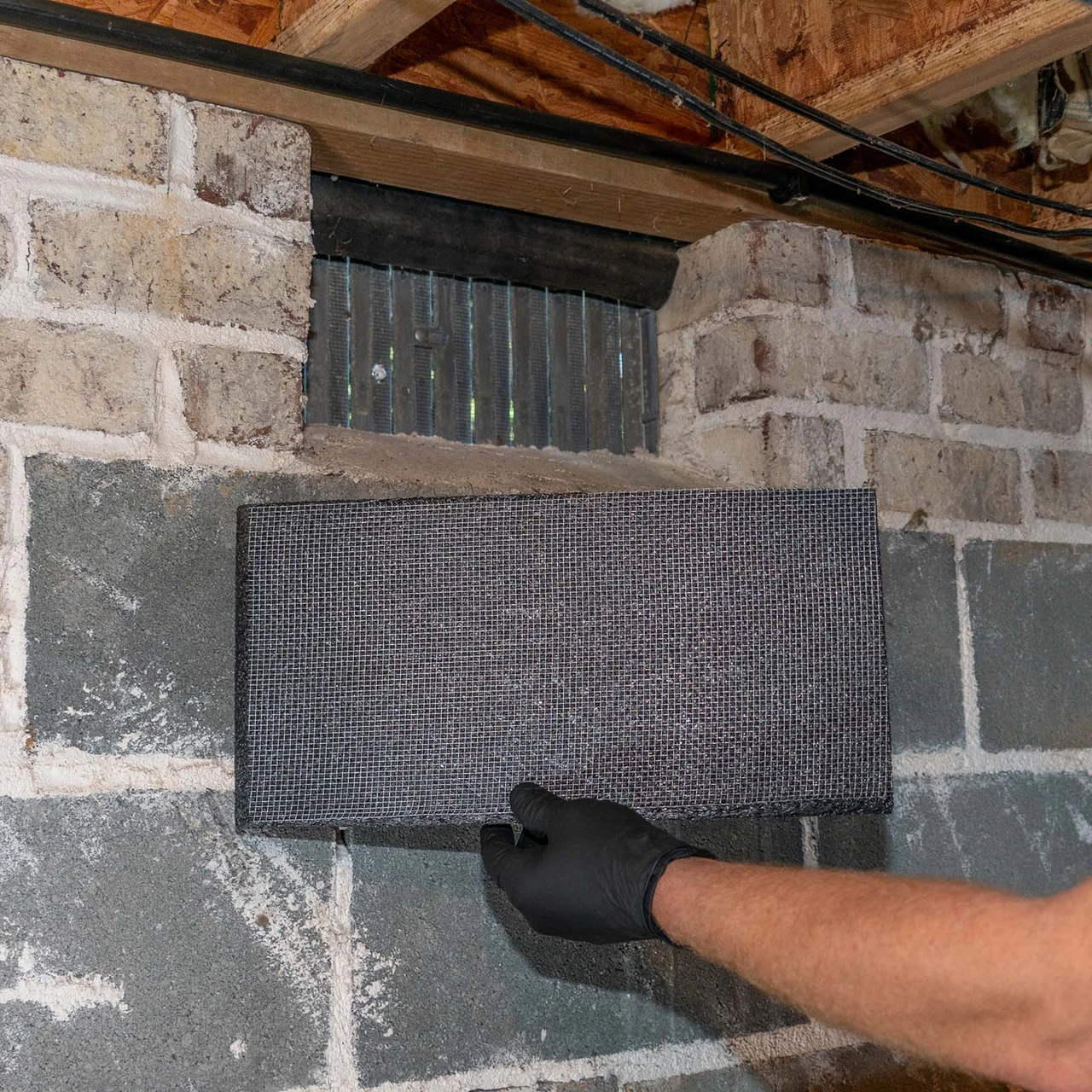 VentBlock+ positioned behind an existing masonry foundation vent before installation