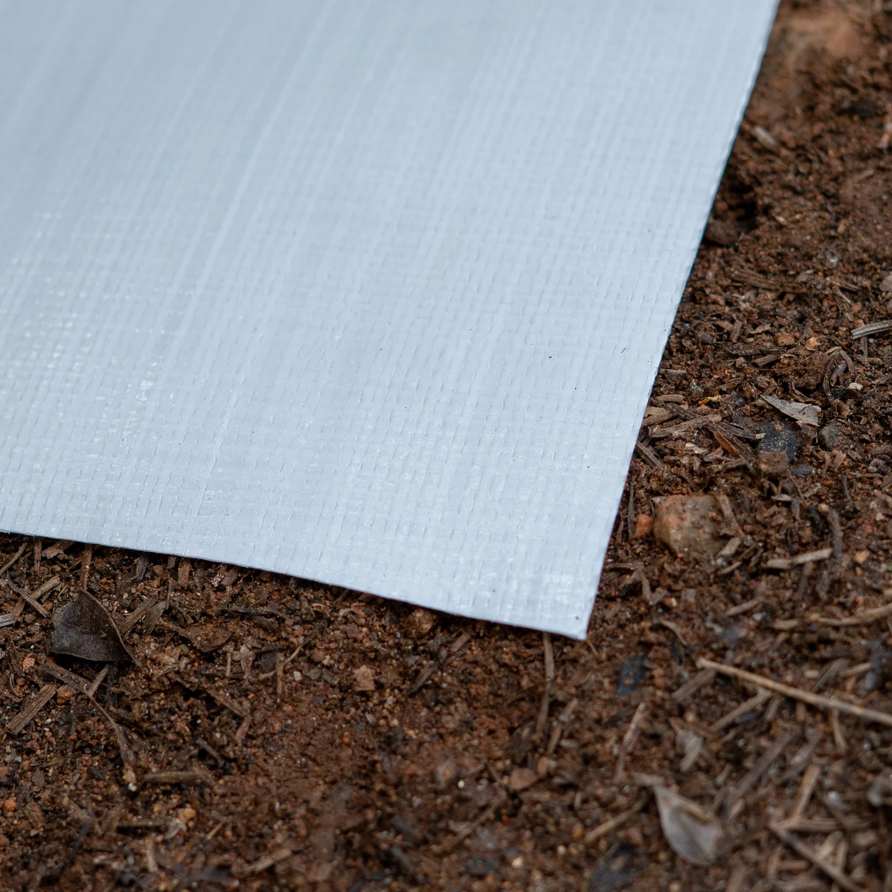 Close up of 10 mil woven coated crawl space vapor barrier