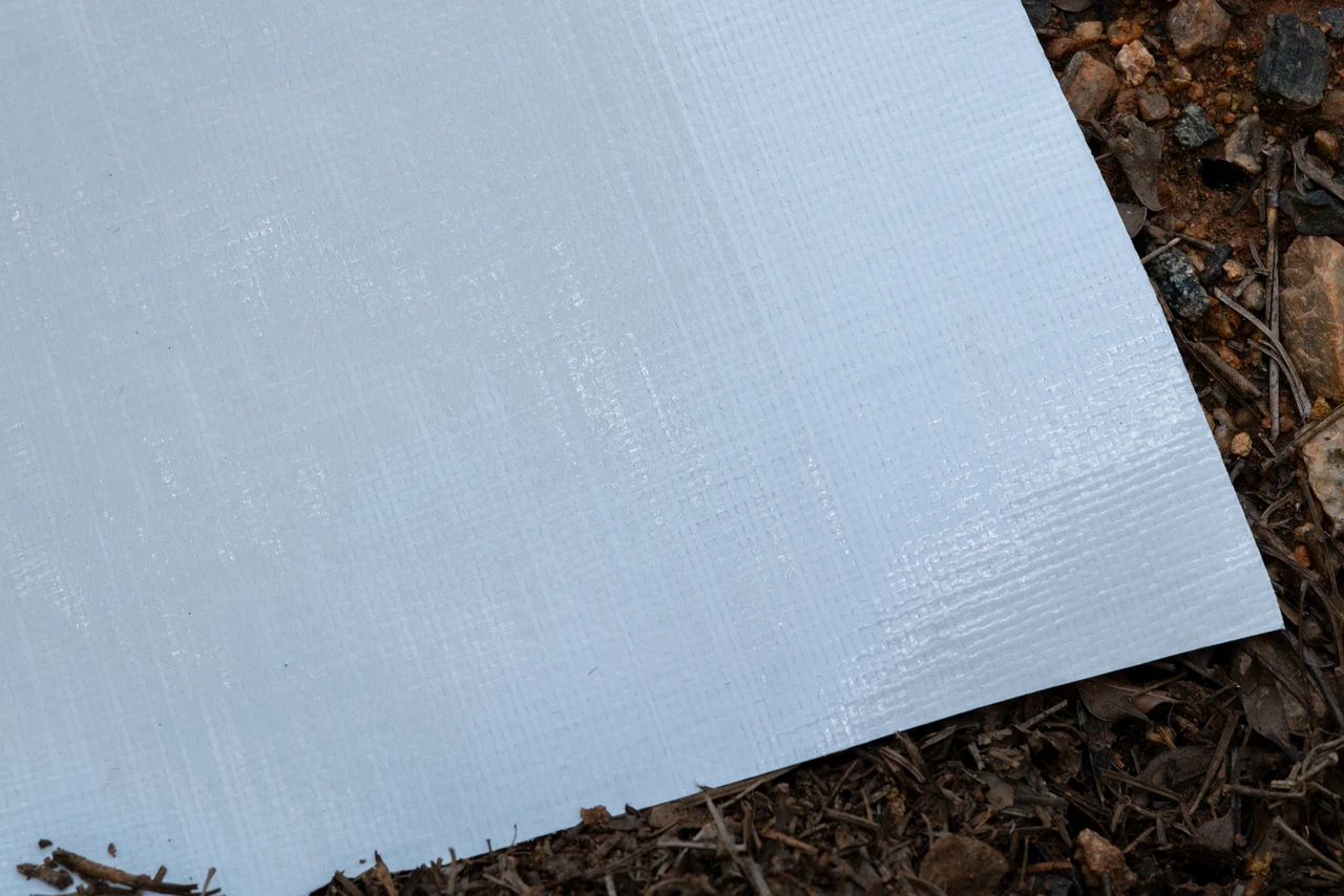 Close up showing texture of 10 mil woven coated crawl space vapor barrier