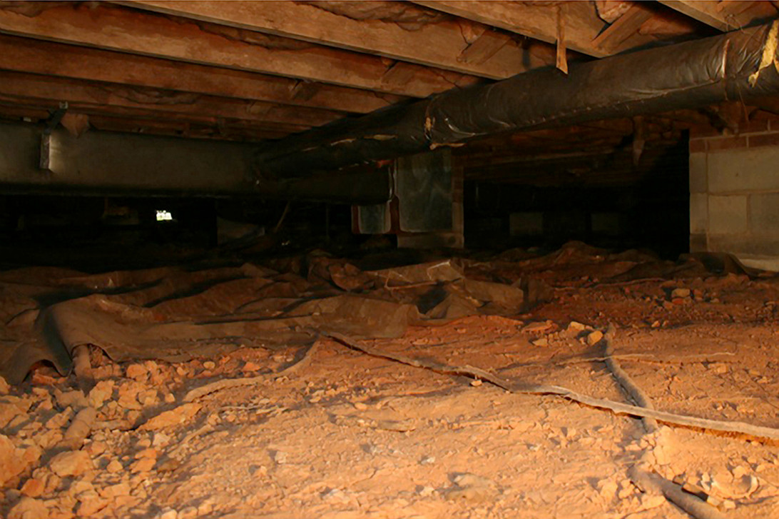 Before I install a vapor barrier, can I just cover up the debris in the crawl space?