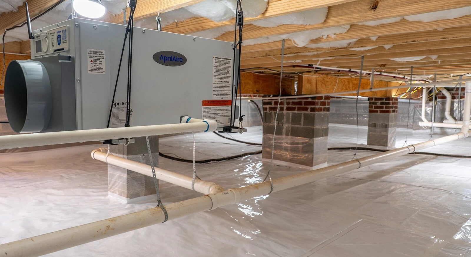 AprilAire E070 crawl space dehumidifier installed in a clean, encapsulated crawl space