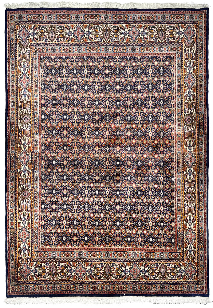 Full view of a Persian Moud Rug on the floor showing its detailed borders and dense central pattern.