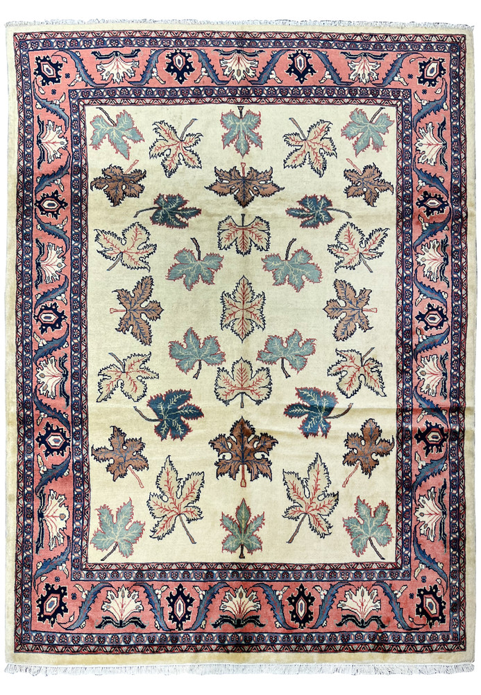 Full view of a hand knotted Persian Farahan rug with ivory field, allover leaf motifs, and salmon pink botanical border