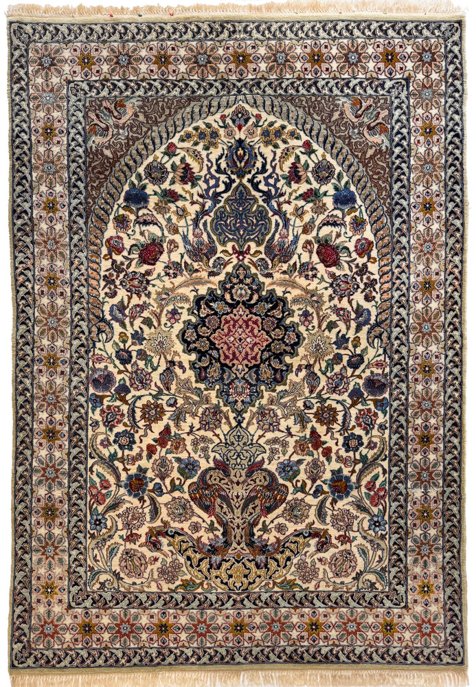 Vintage Persian Isfahan wool and silk rug with floral medallion, mihrab arch, and vase of flowers on an ivory field