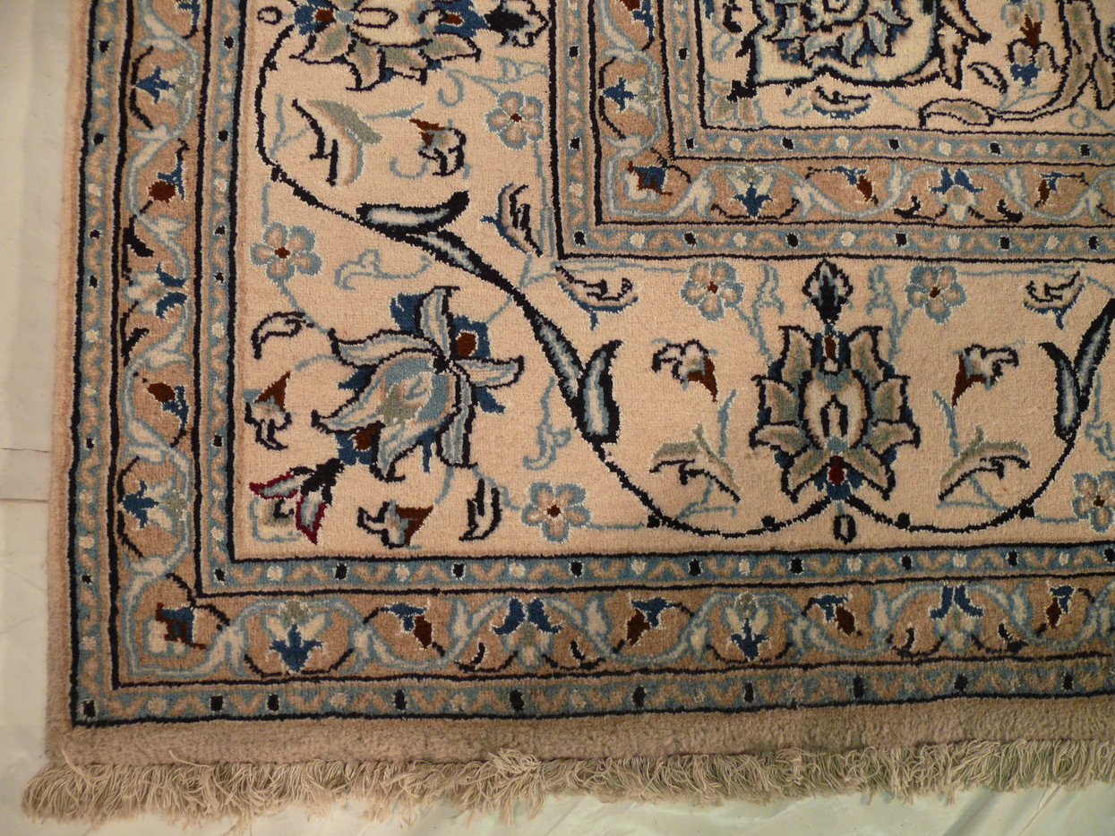 Edge view showing white/ivory guard border and fine wool pile