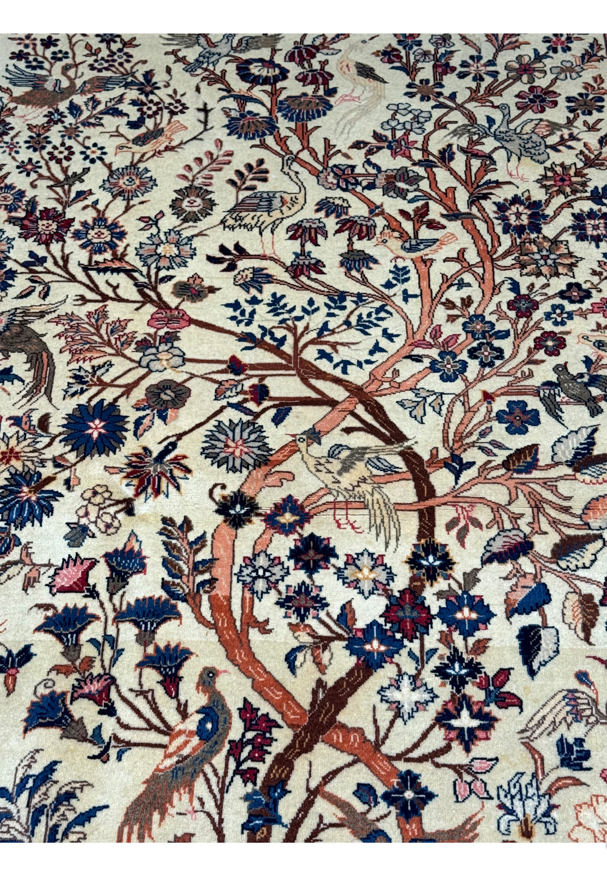 Close-up view of the upper part of a 4'2" x 6'9" Antique Persian Kashan rug, emphasizing the Tree of Life's branches and surrounding animal figures in vibrant hues